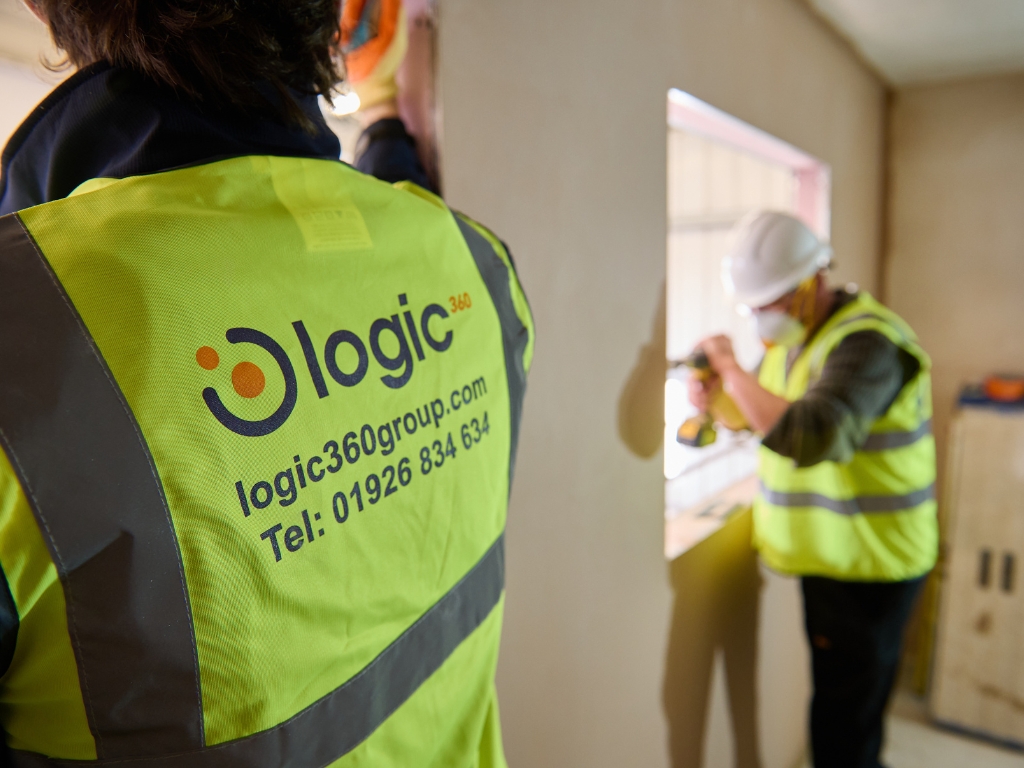 A Logic 360 team member in a branded hi-vis vest on site during a building fit-out.
